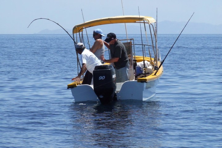 a man riding on the back of a boat in a body of water