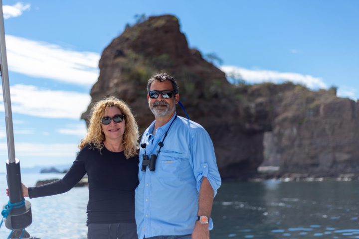 a man and a woman standing in front of a mountain